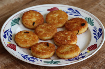 Obraz na płótnie Canvas fresh baked hommade potato pancakes, also named rosti, hash browns, kartoffelpuffer, latkes, draniki - on white plate on wooden background.