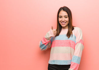 Young cute woman smiling and raising thumb up
