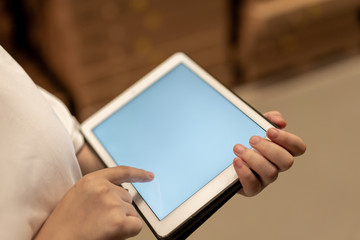 worker hand holding pad for check order pick time in smart factory warehouse