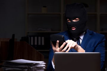 Male employee stealing information in the office night time  
