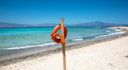 Obraz premium Lifebuoy on beautiful sandy beach and clear sea