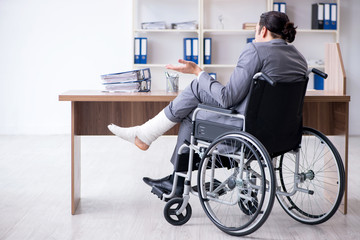Male employee in wheel-chair in the office 