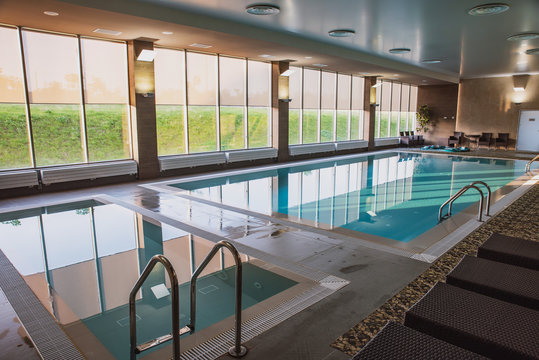 Beautiful Indoor Pool With Jacuzzi With Rattan Furniture And Large Panoramic Windows, Lighting And Finished In Loft Style