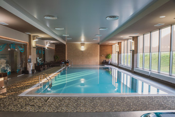 beautiful indoor pool with Jacuzzi with rattan furniture and large panoramic Windows, lighting and finished in loft style