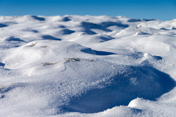 Lovely snowdrifts, formed by wind with a little bit of gras still showing through.