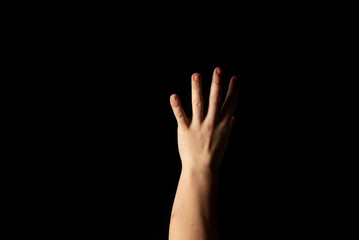 The hand of a young man on a black background