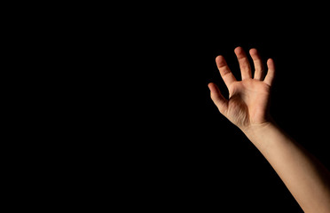 Fototapeta premium The hand of a young man on a black background