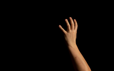 The hand of a young man on a black background
