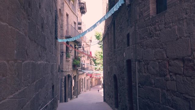 Narrow and old street with garlands of greater celebration in Solsona, Spain.