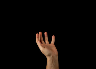 The hand of a young man on a black background