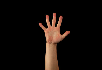 The hand of a young man on a black background