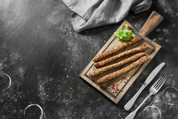 Smoked sausages on a wooden Board. Sausages to beer. Dark background