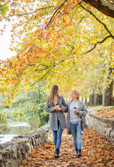 Mother and adult daughter outdoor in park.