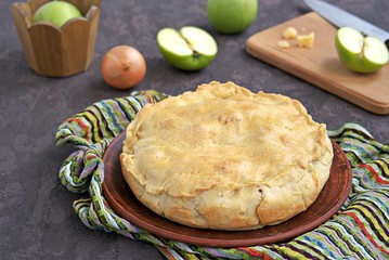 A hearty pie with potatoes, apples and cheese on shortbread dough. Swiss cuisine. Savory pies.