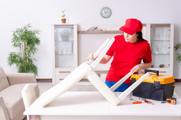 Young woman repairing chair at home 