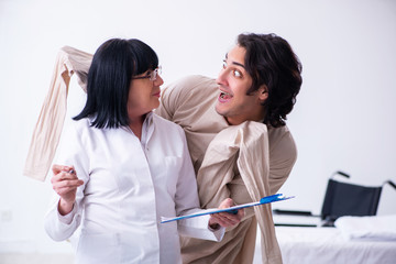 Fototapeta premium Old female psychiatrist visiting young male patient 