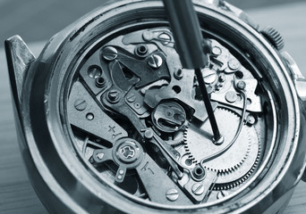 close up macro pic of watchmaker repairing vintage chronograph watch mechanism