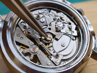 close up macro pic of watchmaker repairing vintage chronograph watch mechanism