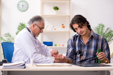 Young male alcoholic visiting old doctor  