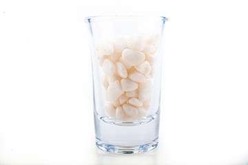 White pebbles stone inside glass with empty copyspace area for slogan or advertising text message,...