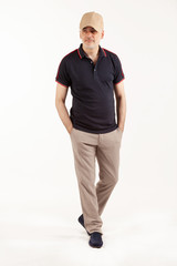 Senior man in ecru pants and black polo shirt isolated on white background