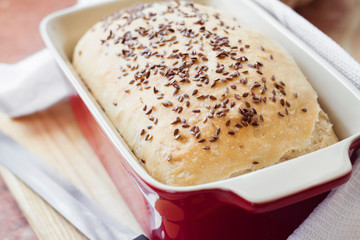 Homemade wheat bread with flax seeds in ceramic baking dish