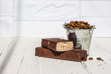 Galvanized bucket full of roasted coffee beans with a chocolate wafer.