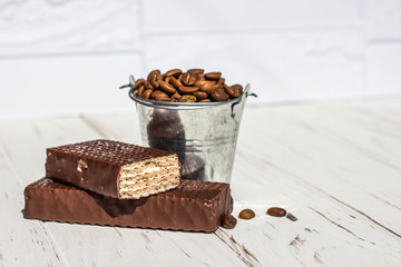 Galvanized bucket full of roasted coffee beans with a chocolate wafer.