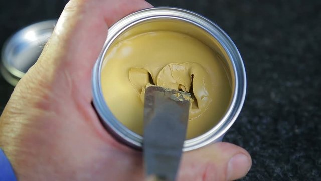 A man dilutes the putty on the metal hardener and mixes it