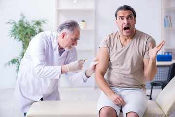 Male patient visitng doctor for shot inoculation 