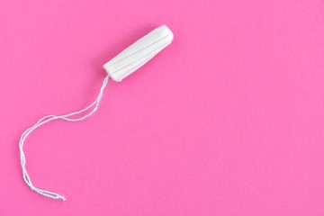 Soft cotton tampon for women period days with selective focus on blurred pink background. Hygiene products for women's monthly menstruation. White protection tampons for female health care. Copy space