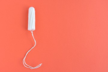 Soft cotton tampon for women period days with selective focus on orange background. Hygiene products for women's monthly menstruation. White protection tampons for female health care. Copy space