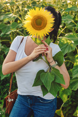 A woman hidden behind the sunflower