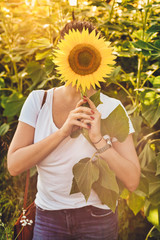 A woman hidden behind the sunflower