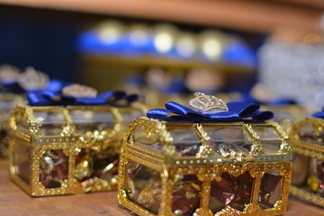 Fototapeta na wymiar Baús transparentes e dourados com doces dentro - Decoração de festa infantil , tema de prncípe.