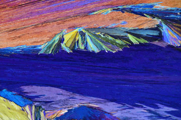 Colorful micro crystals in polarized light. Photo through a microscope.