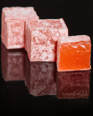Turkish delight, sweets on a black background (dessert sweets) lokum. food background. top view. copy space