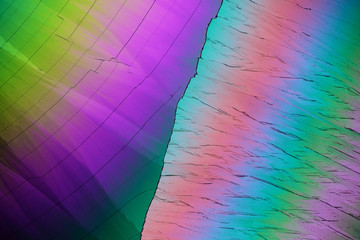 Colorful micro crystals in polarized light. Photo through a microscope.