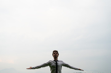 Young man meditating under cloudy sky