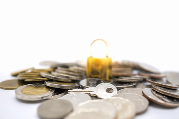 Money, Business and Security Concept.  Close up of silver key on pile of coins with master key lock...
