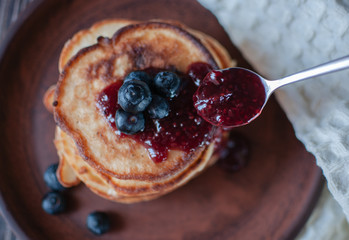 Pancakes with blueberry and honey. On a wooden table with a white towel