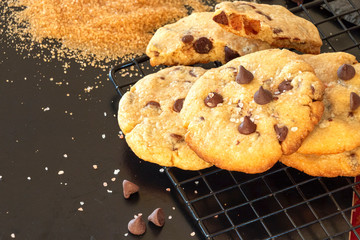 Homemade salted caramel chocolate chips cookies. Dark background.