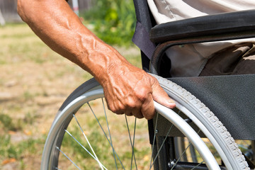 A disabled man is sitting in a wheelchair ,Holds his hands on the wheel. Handicap people Concept.