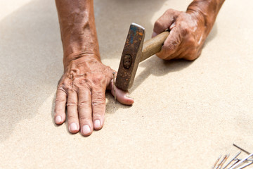 The man hit his finger with a hammer. Professional carpentry, woodwork and people. concept of injury in the workplace. Copy space