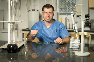 Middle age male laboratory technician  sampling with pipette chemical liquid solution in laboratory