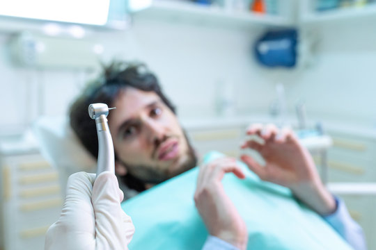 Paura e terrore del dentista con un paziente che guarda il trapano a fresa