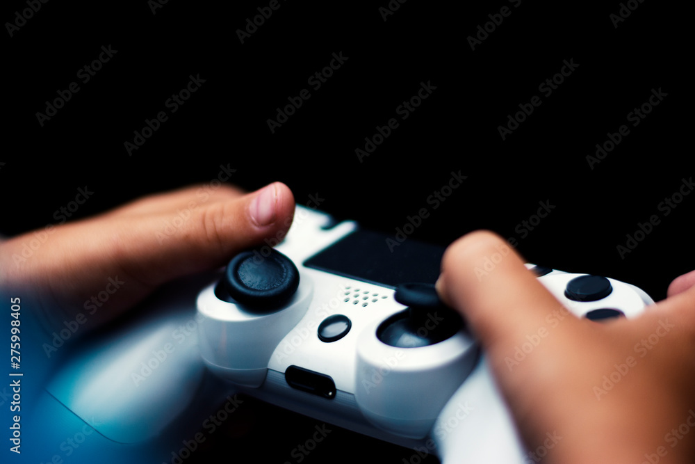 Aufkleber joystick in game isolated in black. close-up of hands holding gamepad in black background. games con