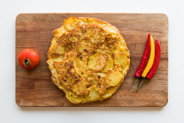 traditional spanish tortilla de patatas with tomato and chillies