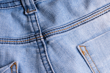 Fototapeta premium Blue denim. Cotton fabric, jeans. Creative vintage background. Pocket and zipper. The line is of poor quality. Cheap item.