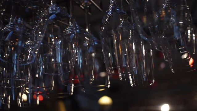 Close-up view of clean washed and polished glasses for wine and other alcoholic drinks hanging over the bar counter. Frame. Decoration,Interior,design concept